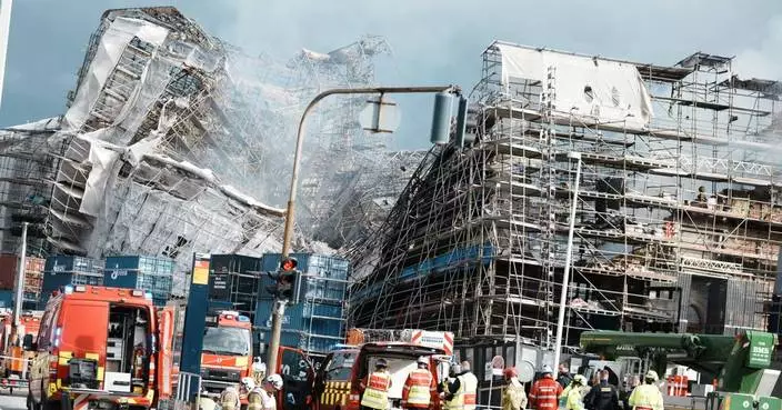 Firefighters tackle scaffolding dangling outside ruins of fire-ravaged Danish landmark