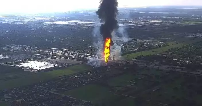 A pipeline explosion is shooting a towering pillar of flame over a Houston suburb