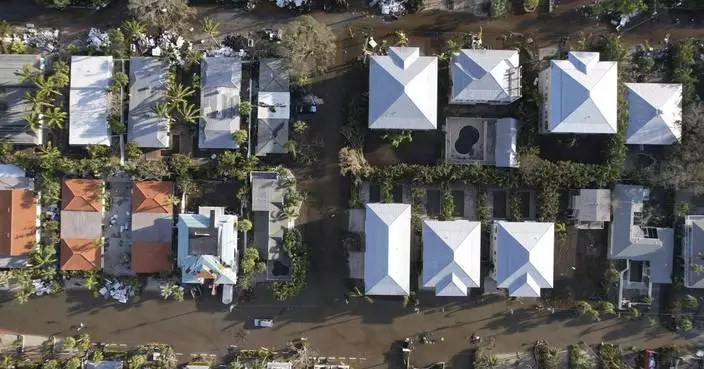 Residents slog through flooded streets, pick up debris after Hurricane Milton tore through Florida