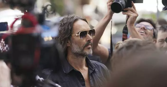 Russell Brand arrives at a London court to face rape and sexual assault charges