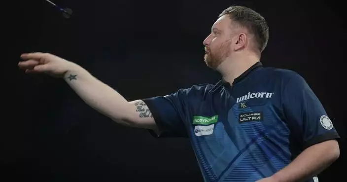 Darts player sorry for repeatedly punching table after tough loss at world championship