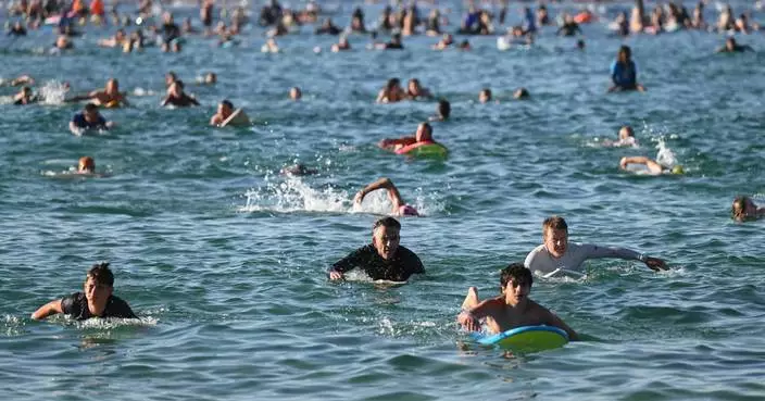 A sunrise crowd gathers at Bondi Beach in solace and defiance after a massacre