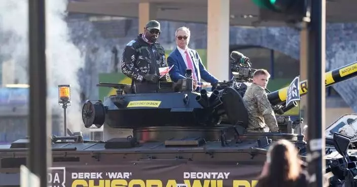 Heavyweight boxer Derek Chisora rides army tank with Nigel Farage to press event