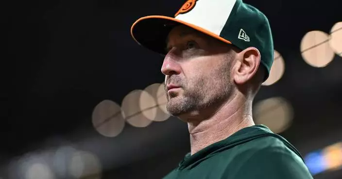 Orioles manager playfully puts on a mask in the dugout to protect himself from foul balls
