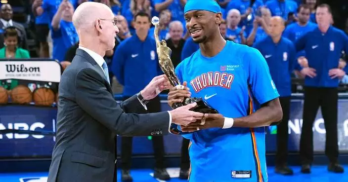 Shai Gilgeous-Alexander gets the MVP trophy from NBA Commissioner Adam Silver