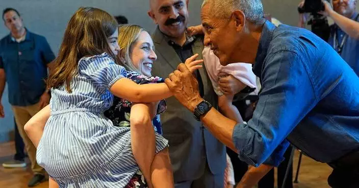 Barack and Michelle Obama surprise first visitors to newly opened presidential center