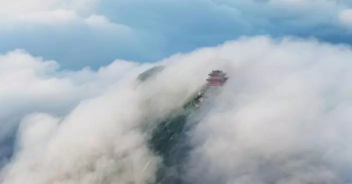 Rolling sea of clouds transforms central China's mountain peak into fairyland