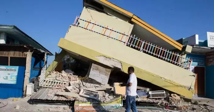 People await aid after powerful earthquake in Indonesia, in photos