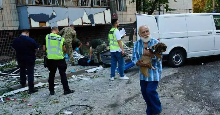 Photos show Kyiv residents clutching pets, collecting bodies after Russian missile and drone attack