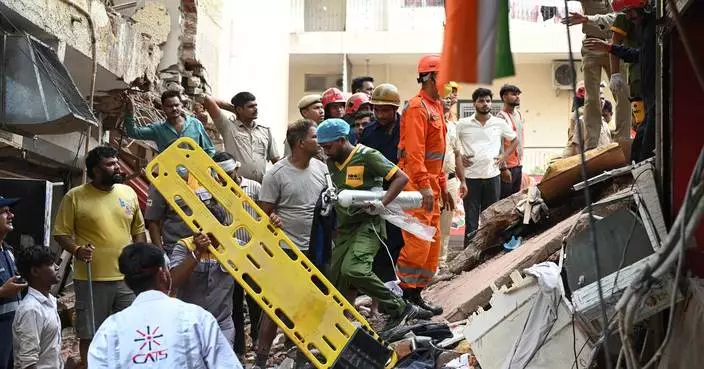 Building collapse in New Delhi kills 1 and traps dozens of others