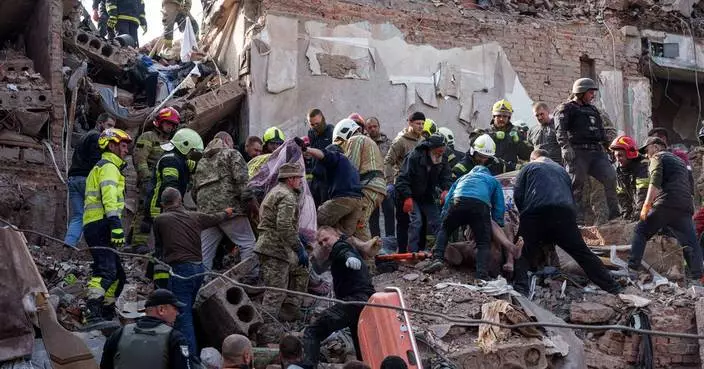 Locals and rescuers clear the rubble of a residential building destroyed in a Russian missile strike, in photos