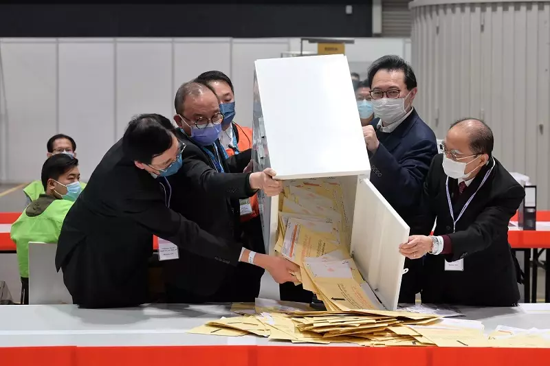 選舉管理委員會主席馮驊和政制及內地事務局局長曾國衞在2021年立法會換屆選舉中央點票站倒出票箱中的選票。選舉事務處圖片