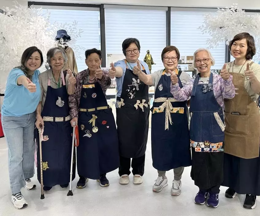 長者麥婆婆(左四)成功將舊牛仔褲改造成圍裙及糉形布袋,深受鼓舞,會繼續研究如何將更多舊衣物改造成為實用物品。中電圖片